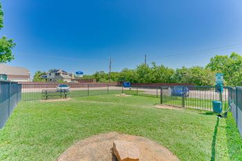 A baseball field with a green fence and a blue sign.